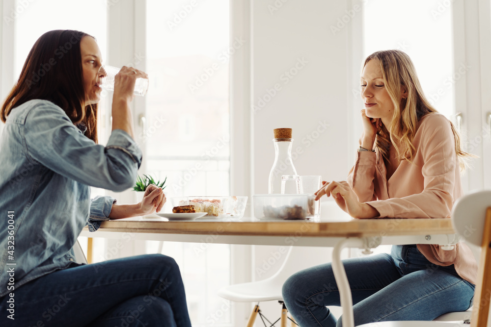 Fototapeta premium Two female friends relaxing over refreshments in a cafeteria