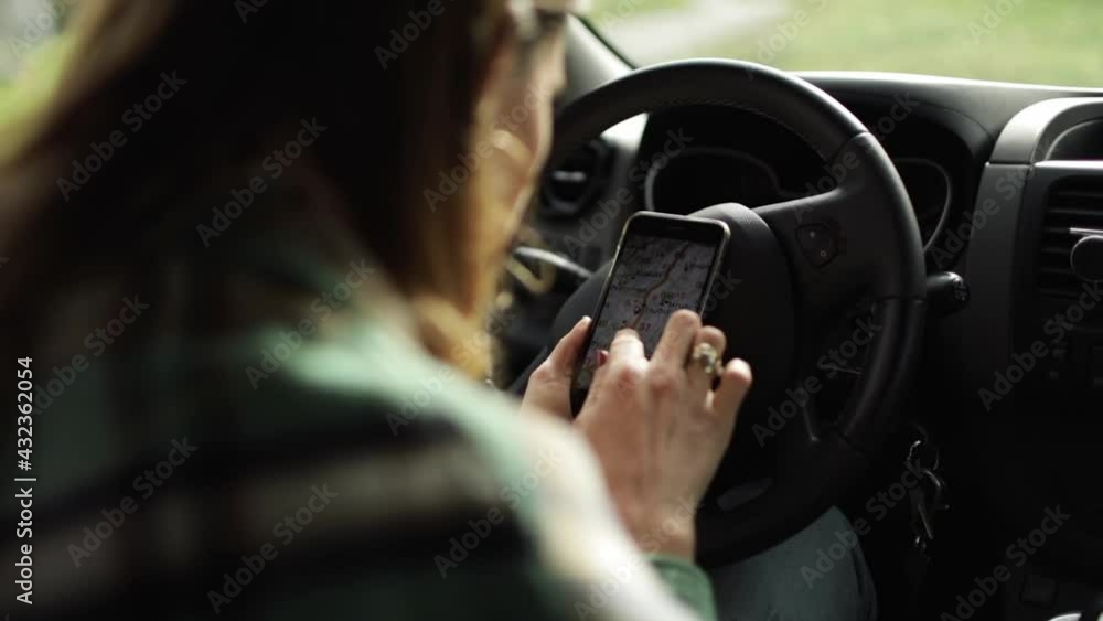 Crop driver using navigation app on smartphone in car Crop driver using navigation app on smartphone in car