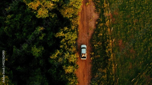 brazil backcountry bush outdoor sunset people on back of pickup truck driving aerial topview drone dirt road holiday travel 4k