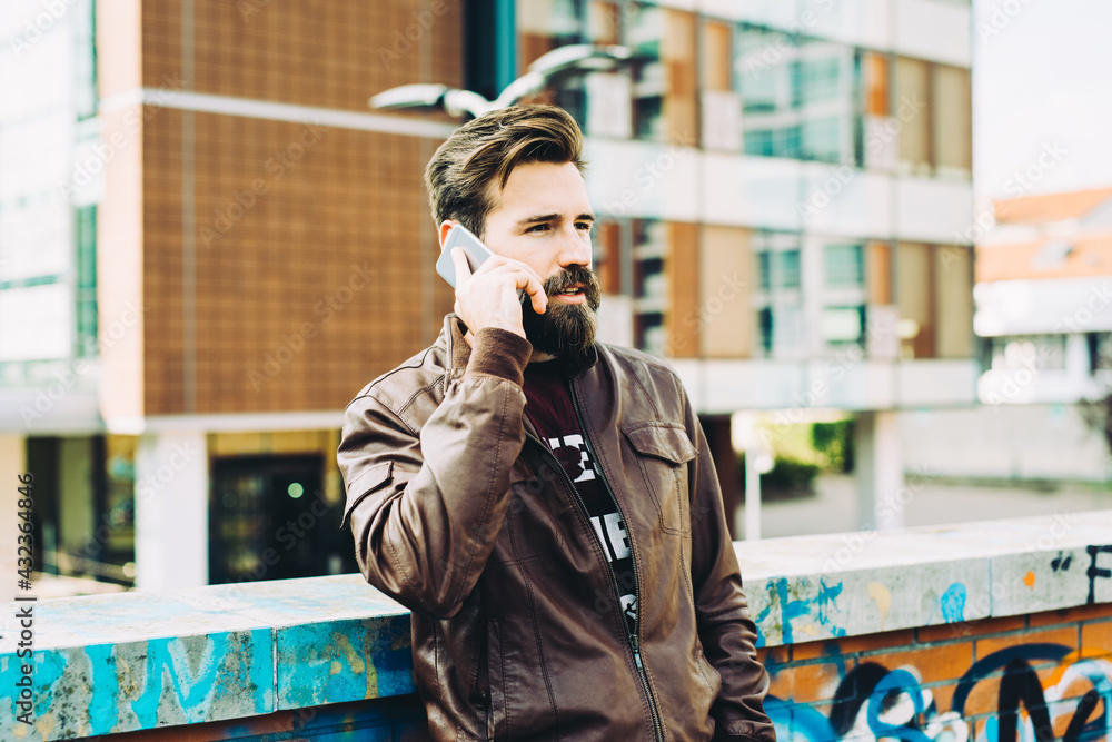 young bearded man talking smartphone serious young bearded man talking smartphone serious
