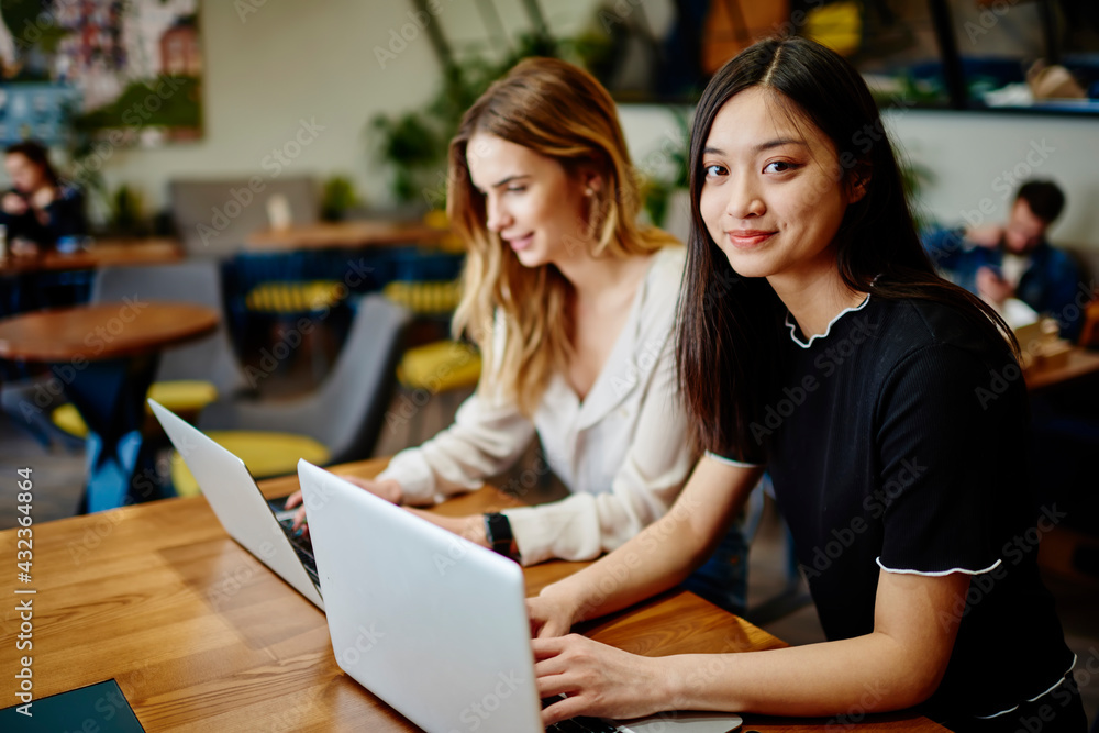 Smiling Asian woman doing project on laptop Smiling Asian woman doing project on laptop