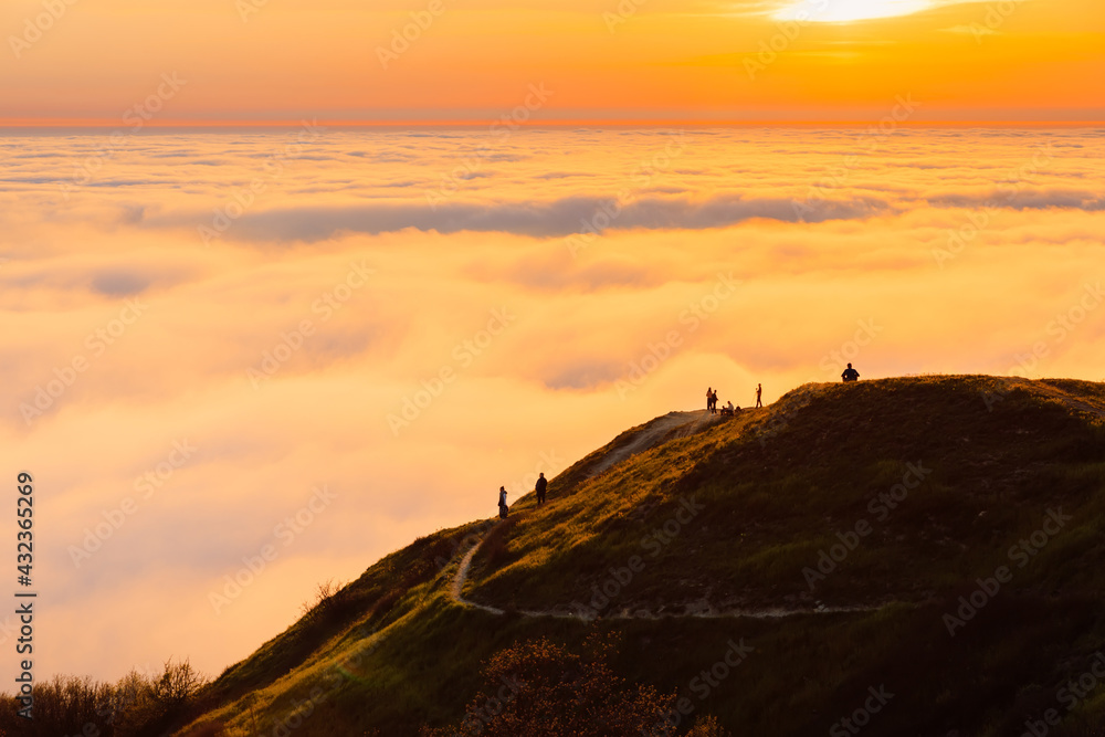 Warm sunset, clouds or fog and mountains with trail