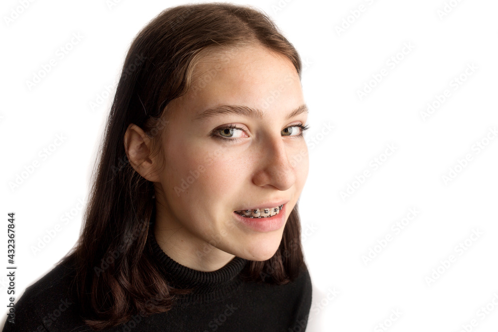 Orthodontic treatment. Dental care concept. Smiling teenage girl with braces. Metal braces close-up on the teeth. Orthodontic treatment. Dental care concept. Smiling teenage girl with braces. Metal braces close-up on the teeth.