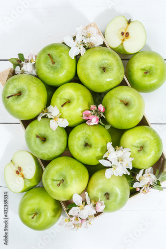 Apples fruits green apple fruit box on wooden board portrait format with leaves and blossoms