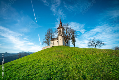Sveti Tomaz, Slovenia - View of the church of Sveti Tomaz (St. Thomas) at sunset in the Skofja Loka area with clear golden and blue skies. Autumn time in the Slovenian Alps
