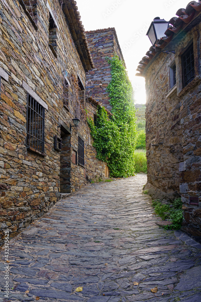 Narrow street of medieval old town with flash of light between buildings. Patones de Arriba Madrid. Narrow street of medieval old town with flash of light between buildings. Patones de Arriba Madrid.