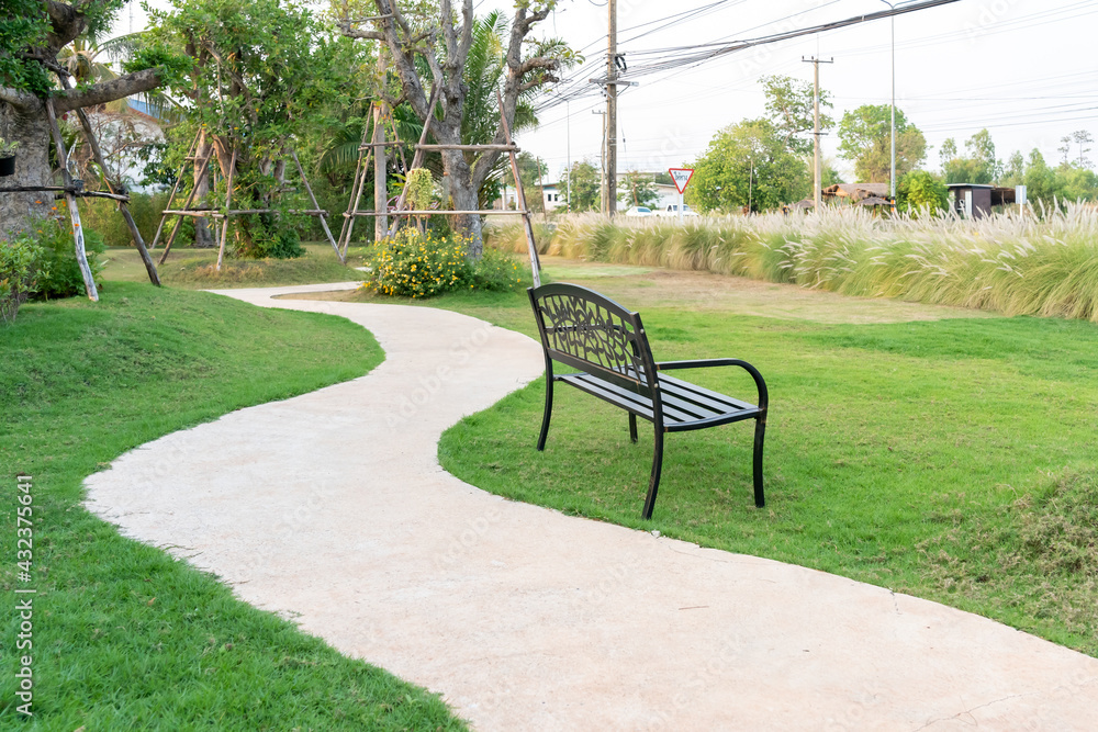 black public bench and green grasses, at the shop. black public bench and green grasses, at the shop.