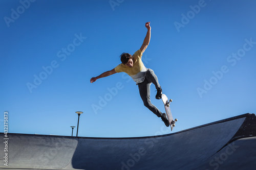 Caucasian man jumping and skateboarding on sunny day photo
