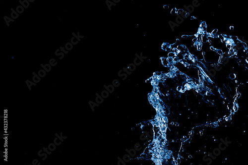 Splashing water on black background. Free space for text. Macro photo.