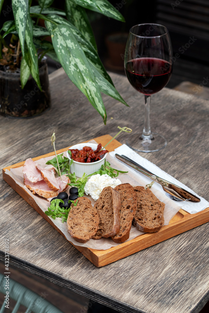 Wine and snack set. Flat-lay of wineglasses and cheese and appetizers board over concrete background, top view. Party food concept, cafe. Wine and snack set. Flat-lay of wineglasses and cheese and appetizers board over concrete background, top view. Party food concept, cafe.