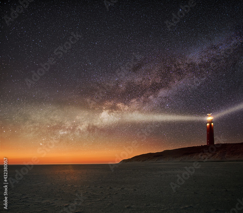Night image of the Texel lighthouse serving as a navigation beacon for ships with starry nightsky with Milky way galactic core photo