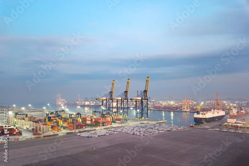 Aerial drone view above dockyard. Scenic view of cargo industrial commercial port in dawn. Professional business logistics and transportation of cargo ship.