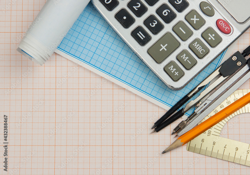 Mathematical instruments over the corner of a math graph paper with copy space for text. Math graphic tools concept. Mathematical instruments over the corner of a math graph paper with copy space for text. Math graphic tools concept.