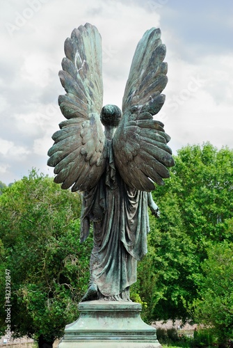 Bronze statue of an angel viewed from the back in Bath, UK