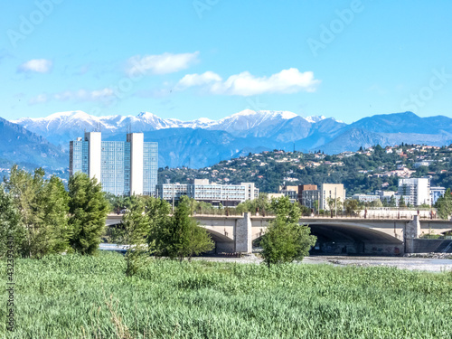 Bâtiment de la Préfecture des Alpes Maritimes et pont Alexandre III à Nice au pied des sommets enneigés du Mercantour dans le Sud de la France sur la Côte d'Azur