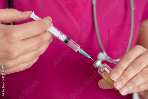 Female nurse in medical uniform. Injection vaccine drug in female doctor hands. medicine and vaccine concept.
