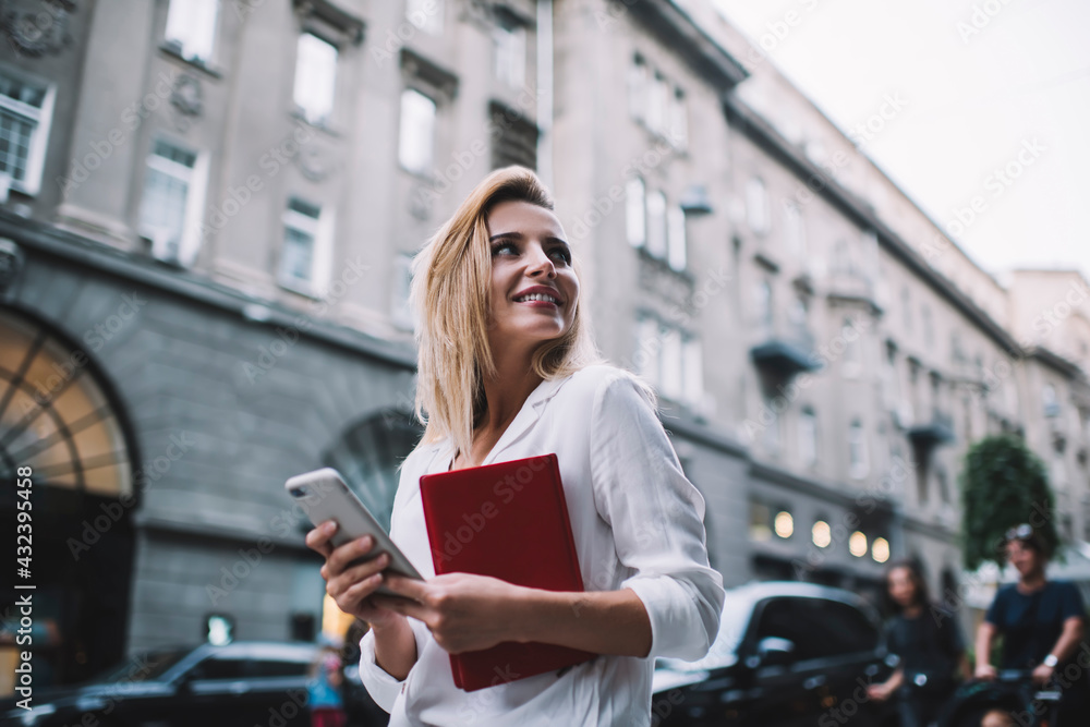 Smiling businesswoman with notebook on street
