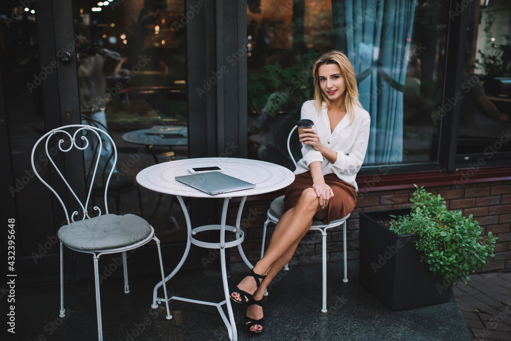 Alluring woman with coffee to go in outdoor cafe Alluring woman with coffee to go in outdoor cafe