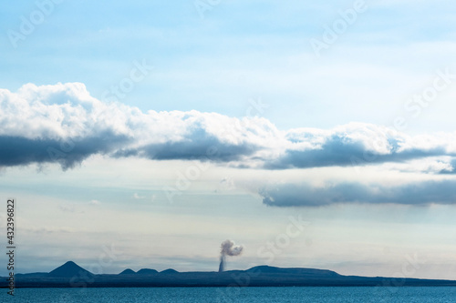 The magma jet and the column of smoke from the Fagradalsfjall volcano on the Reykjanes peninsula between Mount Keiler (left) and mountains Festarfjall, Fiskidalsfjall, Húsafell. photo