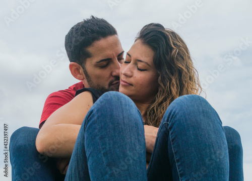 Young couple in love kissing and laughing in a park