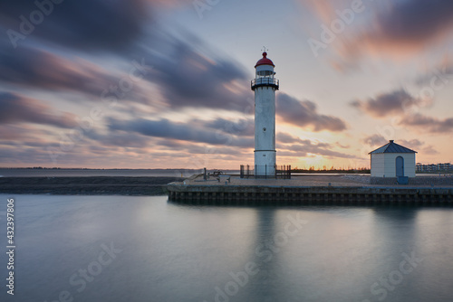 lighthouse with sunset and clouds passing by