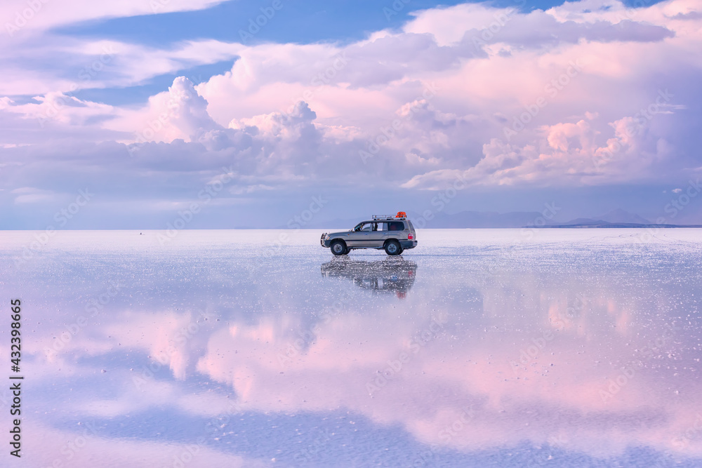 off-road vehicle stands on the salt flat of Uyunu at sunset - Altiplano, Bolivia, South America. Photo does not noise, grain or lens dust. It is pieces of salt and small stones