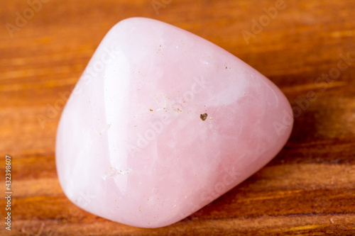 Rose quartz stone on wooden table photo