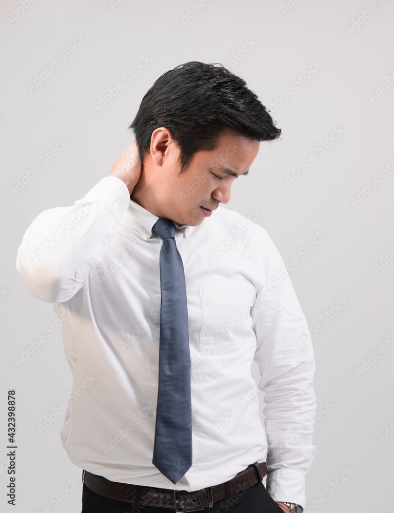 Neck ache concept of asian businessman. Young man looking painful expression. Portrait of young male feeling pain while touching his neck with hand. Man suffering from neckache office syndrome. Neck ache concept of asian businessman. Young man looking painful expression. Portrait of young male feeling pain while touching his neck with hand. Man suffering from neckache office syndrome.