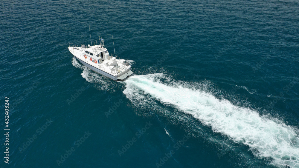 Aerial drone photo of Hellenic Coastguard powerboat cruising in high speed near port of Piraeus, Attica, Greece
