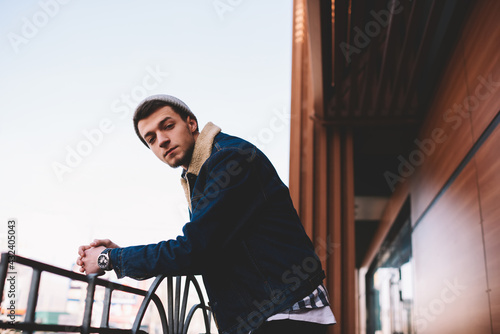 Wallpaper Mural Young man leaning on railing near wooden house Torontodigital.ca