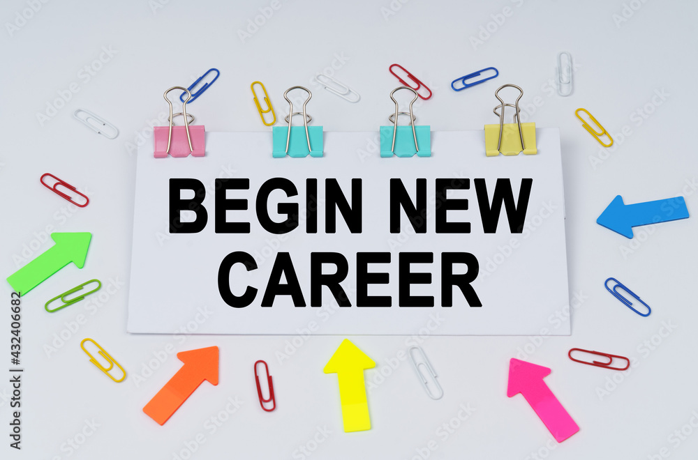 On the table there are paper clips and directional arrows, a sign that says - Begin New Career On the table there are paper clips and directional arrows, a sign that says - Begin New Career
