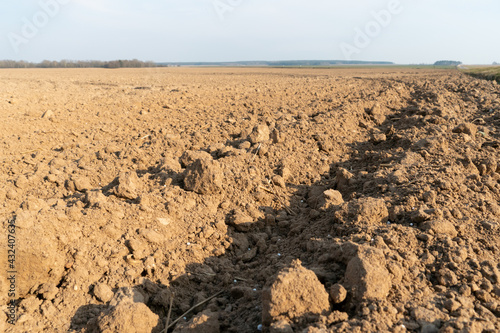 Deep furrows in the ground after working the tractor with the plow. Plowing the land. treatment of the top layer of soil to saturate the soil with oxygen and destroy the seeds and roots of weeds.