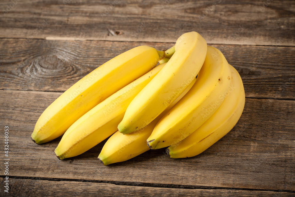 Fresh bunch of bananas on wooden table Fresh bunch of bananas on wooden table