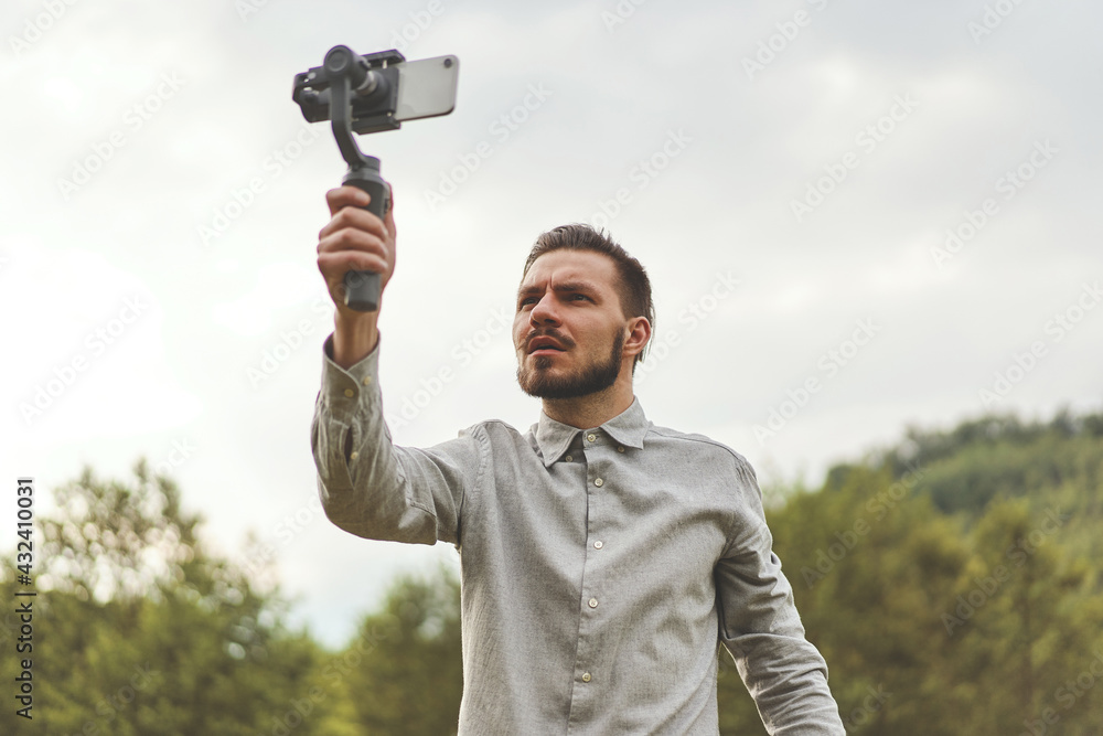 Portrait of businessman recording video presentation at smartphone with steadycam Portrait of businessman recording video presentation at smartphone with steadycam