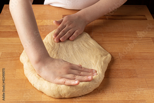 baby knead dough on a wooden board
