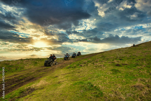 Quad atv caravan on dirty and dusty mountain hills photo