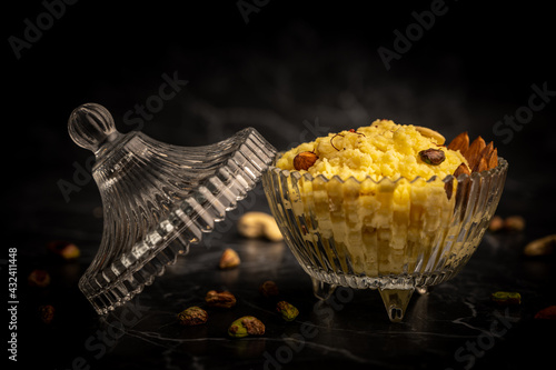 Palkova placed in a glass container with cashews scattered all around and ready to be served. photo