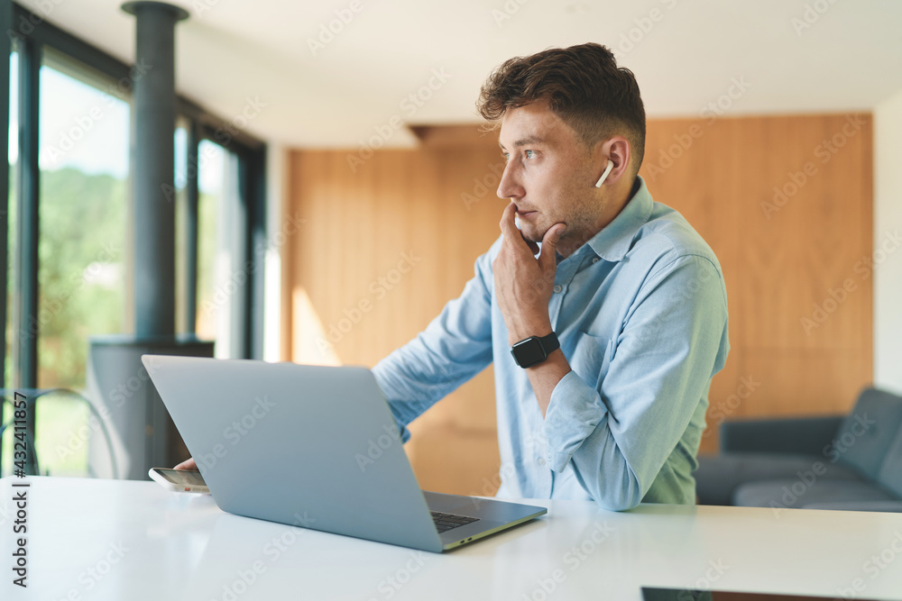 Successful business man working from home with laptop and smartphone Successful business man working from home with laptop and smartphone