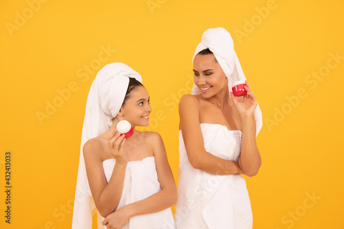 family spa. mother and teen girl hold face cream. skincare. relaxing together. beauty treatment.