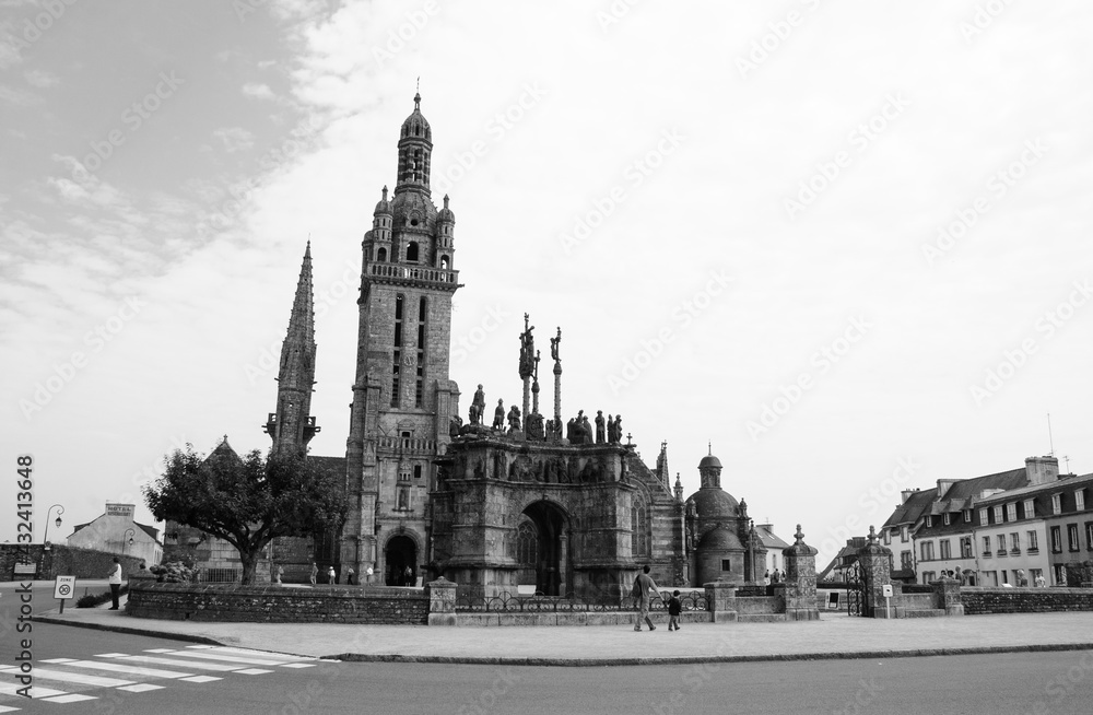 Parish enclosure (parish church elaborately decorated with sculpture groups and surrounded by an entirely walled churchyard) in Pleyben. Brittany, France. Black white historic photo.