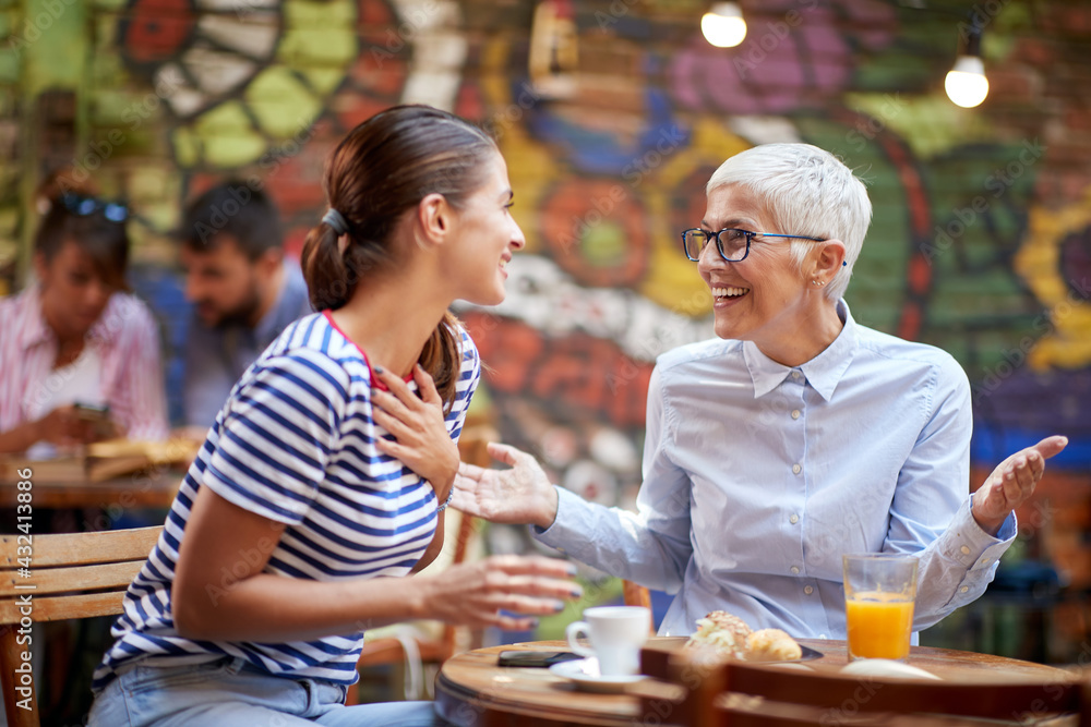 A young girl is enjoying a company of her older female friend while the have a drink at a bar. Leisure, bar, friendship, outdoor A young girl is enjoying a company of her older female friend while the have a drink at a bar. Leisure, bar, friendship, outdoor