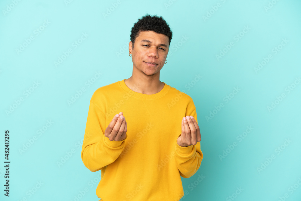 Young African American man isolated on blue background making money gesture but is ruined Young African American man isolated on blue background making money gesture but is ruined