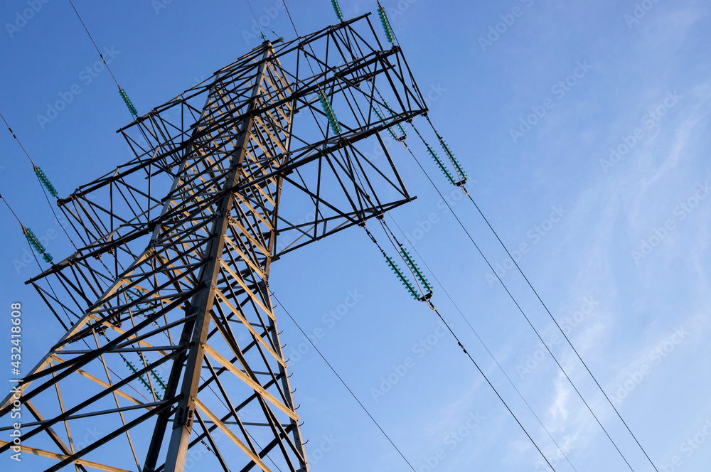 Electricity transmission tower against blue sky. Wires, insulators. 