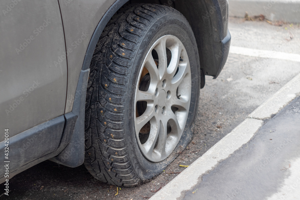 broken car wheel close-up. rubber tire with spikes on the wheel