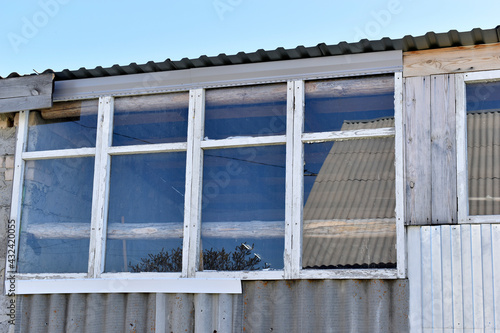 An old greenhouse of rotten windows with cracked paint