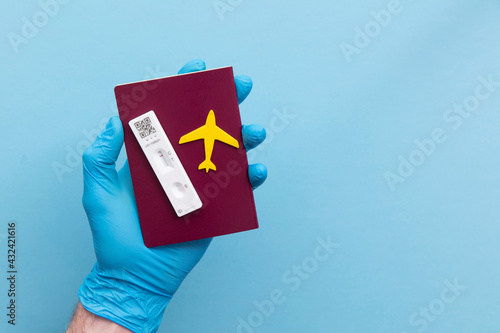 Covid19 travel passport. Person holds lateral antigen test and plane photo