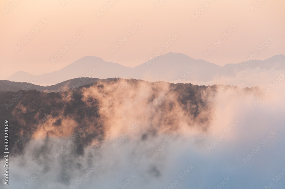 Nascer do Sol na serra do Mar no Paraná com nuvens baixas na planície litorânea. 