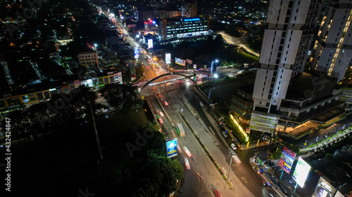 Traffic jam on the polluted streets of Bekasi at night. The traffic congestion is limited in few areas, selective focus on the road. Bekasi, Indonesia, May 8, 2021