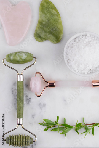 Face roller and guasha massager. Facial skin care, anti age products and sea salt. Chinese Gua Sha massage tools from rose quartz and nephrite. 