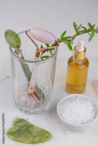 Face roller and guasha massager. Facial skin care  anti age products  sea salt and essential oil. Chinese Gua Sha massage tools from rose quartz and nephrite. 